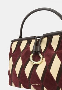 Borsa in suede trapuntato bordeaux, marrone e crema con motivo a diamante; presenta un dettaglio hardware in anello dorato e manici in pelle scura.