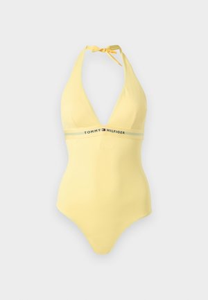 Gelber Neckholder-Einteiler mit Tommy Hilfiger-Logo und Flagge auf einem elastischen Band unter der Brust, auf einfarbigem Hintergrund dargestellt.