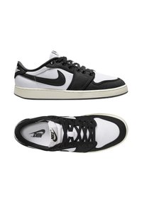 Sneakers Nike con tomaia in tela e sintetico nero e bianco, lacci neri, suola in gomma e logo bianco sulla linguetta e sul lato.