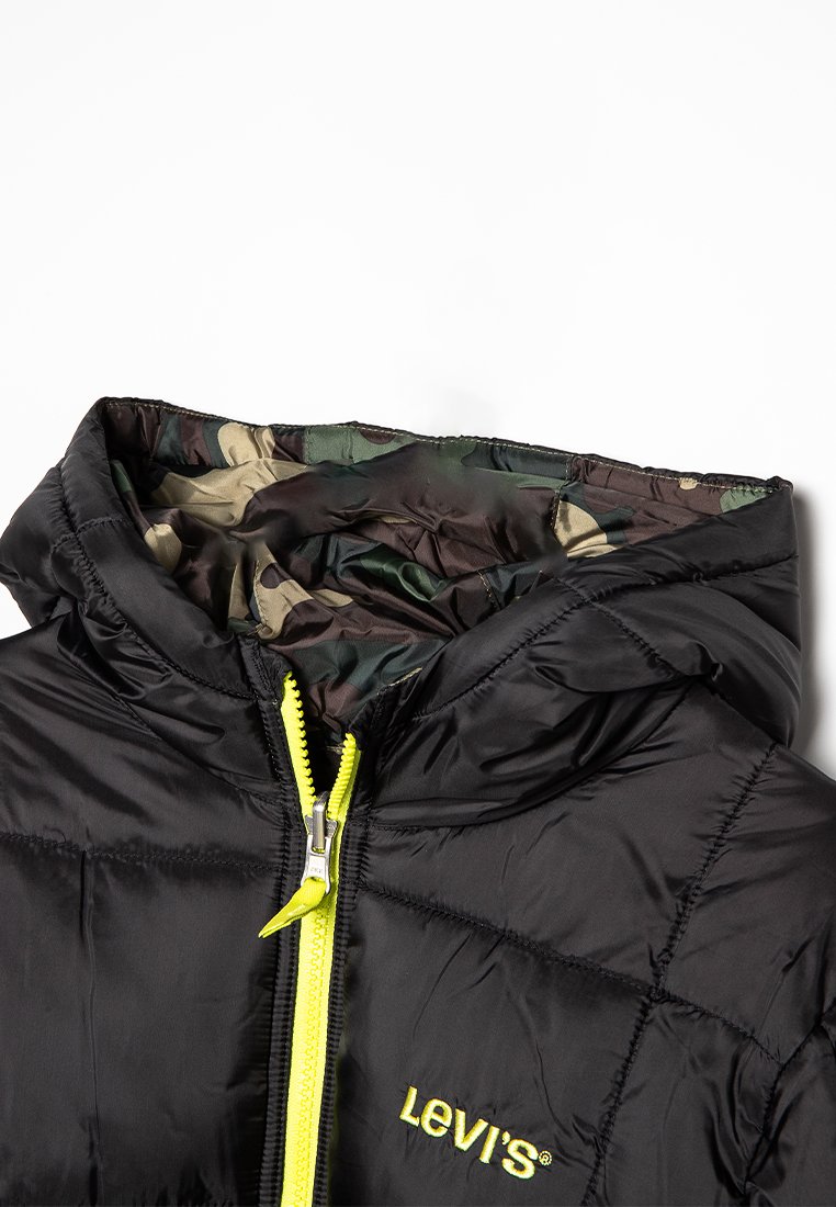 Doudoune noire avec doublure de capuche à motif camo, fermeture éclair jaune fluo et logo Levi's brodé sur la poitrine.