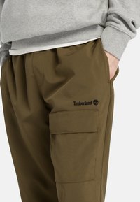 Olivgröna cargobyxor i mjukt material med resårmidja, med sidofickor och broderad Timberland-logotyp.