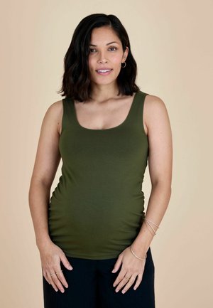 Olijfgroene tanktop met een ronde hals en een aansluitend ontwerp, gemaakt van een glad, rekbaar materiaal. Geaccentueerd met een plooidetail aan de zijkant.