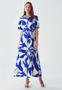 Modrá a bílá vzorovaná maxi šaty s límečkovým výstřihem, krátkými rukávy, knoflíky vpředu a stahovacími šňůrkami v pase pro zvýraznění postavy.