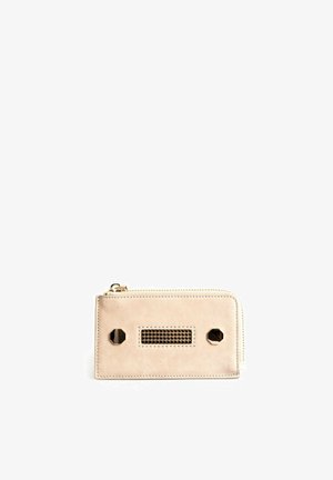 Beige leather wallet with a zipper closure, featuring metallic hexagonal accents and a mesh panel in the center. Lightweight and compact design.