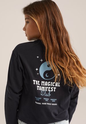 Zwarte langemouwen shirt met een ronde blauwe grafiek met hemelse elementen en tekst: "THE MAGICAL MANIFEST Club" in het wit.