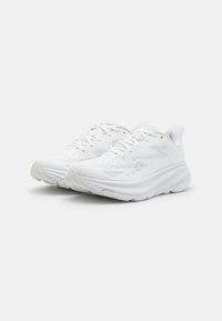 Scarpe sportive bianche con tomaia in mesh traspirante, linguetta imbottita e suola spessa in schiuma. Presentano un motivo testurizzato e un design con lacci.