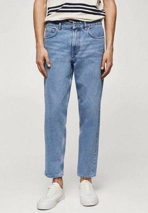 Vaqueros de denim azul claro con corte recto, cinco bolsillos y un acabado ligeramente deslavado. Llevados con zapatillas blancas.
