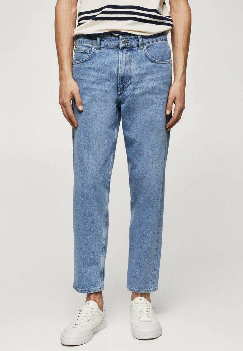 Jeans in denim azzurro chiaro con taglio dritto, cinque tasche e una finitura leggermente sbiadita. Indossati con sneakers bianche.