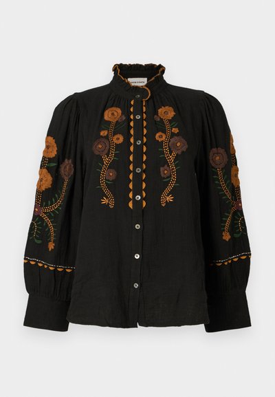 Črna bluza z ovratnikom z volančki, okrašena s pisanimi cvetličnimi vezeninami v odtenkih rjave in zelene, poudarjena z gumbnimi detajli in elastičnimi rokavi.