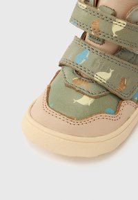 Πράσινο υφασμάτινο παπούτσι με μπεζ δερμάτινες λεπτομέρειες. Διαθέτει δύο λουριά με βέλκρο και σχέδιο φύσης με φάλαινες και ψάρια. Υφή στην σόλα για καλύτερη πρόσφυση.