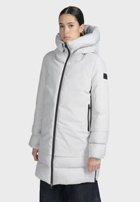 Biała kurtka puchowa z wysokim kołnierzem i zapięciem na zamek, z bocznymi kieszeniami i elastycznymi mankietami. Gładka tekstura i elegancki design.