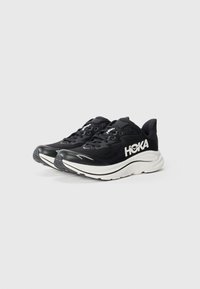 Schwarze Laufschuhe mit einem strukturierten Mesh-Obermaterial, weißem Logo, dickem gepolstertem Sohlen und Gummi-Außensohle für besseren Halt. Die Schnürsenkel sind integriert für einen sicheren Sitz.