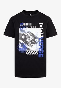 Camiseta negra con estampado gr�áfico de zapatillas Converse de caña alta negras, texto azul y blanco "CONVERSE ALL STAR" y "1908", además de elementos de diseño.