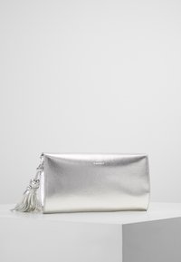 Metalisk sølv clutch taske med en glat tekstur, rektangulær form og en dekorativ kvast. Har et logo præget på forsiden.