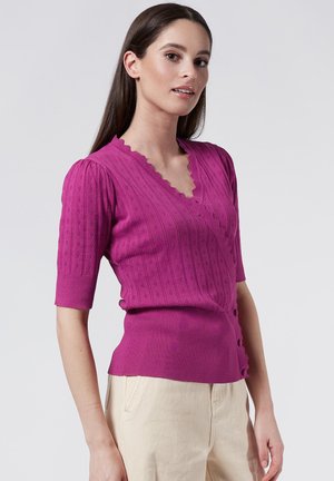 Fuchsia knitted top with short sleeves, featuring a scalloped V-neck, ribbed texture, and decorative buttons along the side.