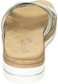 Sandale marron avec une semelle intérieure douce, une sangle argentée, une semelle extérieure texturée et des détails blancs. Caractérisée par des bords tressés et une semelle rembourrée.