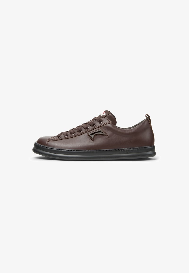 Brown leather sneaker with round toe, lace-up design, contrasting black rubber sole, subtle logo detail on the side. Smooth texture.