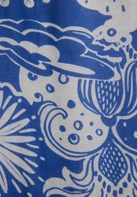 Sinine ja valge kangas, millel on lilleline kujundus koos keerleva joone, punktide ja keerukate joonte mustritega tekstuurilisel taustal.