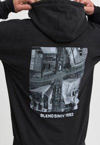 Sudadera negra con un estampado gráfico en la parte posterior que representa un paisaje urbano en escala de grises. Presenta el texto "BLEND SINCE 1993" debajo del diseño.