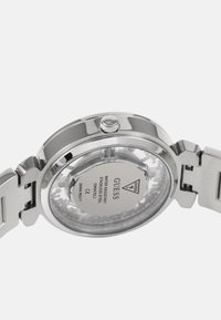 Roostevaba terasest kell, millel on poleeritud hõbedane korpus, läbipaistev tagakülg ja ümmargune kuju. Küljel on reguleerimiseks kroon.