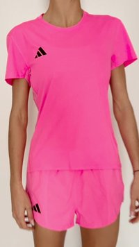 Rózsaszín sportpóló és rövidnadrág szett légáteresztő anyagból. Fekete Adidas logó díszítésekkel a pólón és a rövidnadrágon.
