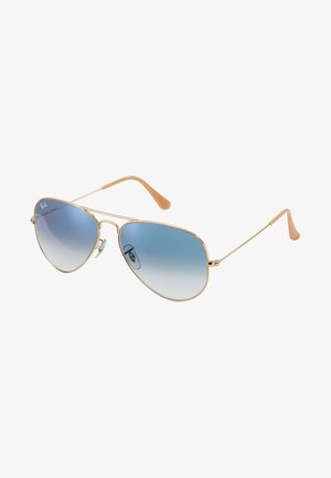 Goldfarbene Metall-Aviator-Sonnenbrille mit blauen Verlaufs-Gläsern und cremefarbenen Gummi-Akzenten an den Bügeln. Klassisches dünnes Rahmendesign.