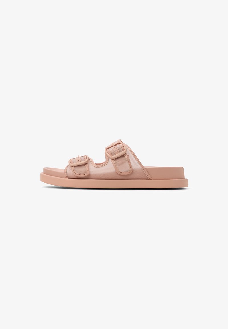 Sandales à glissière roses avec deux boucles réglables, fabriquées à partir d'un matériau doux, dotées d'une semelle plate et d'une surface lisse et texturée.