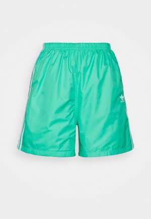 Shorts de sport verts Adidas avec ceinture élastique et trois bandes blanches de chaque côté, affichés sur un fond clair uni.