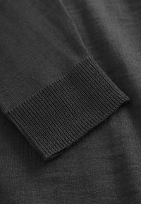 Dunkelgrauer gestrickter Pullover mit geripptem Bündchen. Weiche Textur, schlanker Schnitt, glatte Oberfläche, subtile Farbschattierungen, keine sichtbaren Muster oder Hardware.