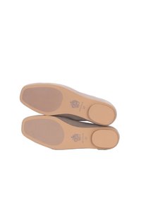Beige lavhælede sko med en glat overflade, gummisåler med ribbet mønster og præget branding på bunden.