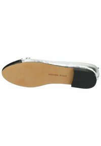 Ballerines métalliques argentées avec un embout noir, texture lisse, petit talon et semelle marron clair avec l'impr®imé de la marque.