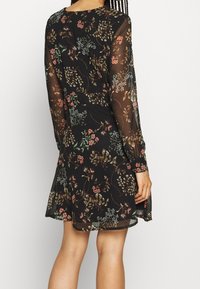 Schwarzes Blumenkleid mit langen, durchsichtigen Ärmeln, das eine Vielzahl bunter Blumen und Blätter zeigt. A-Linie-Silhouette, strukturierter Stoff.