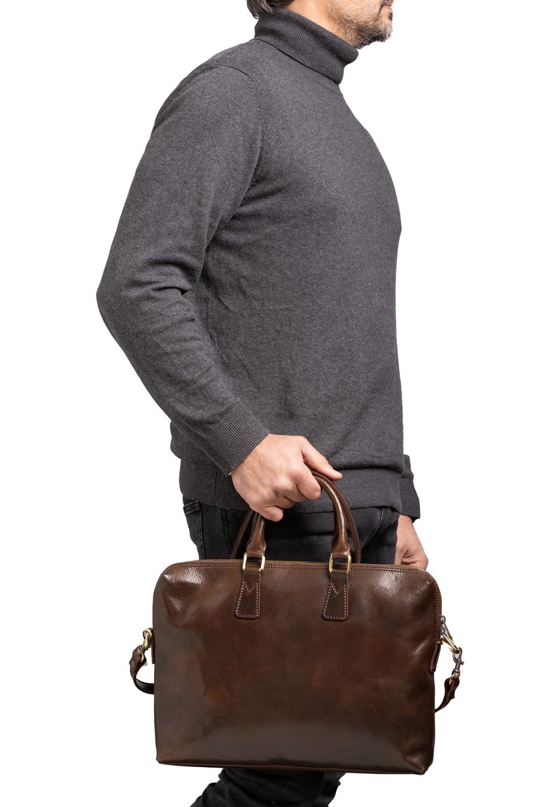 Attaché en cuir marron avec doubles poignées, texture lisse, accents en métal doré et une bandoulière amovible.