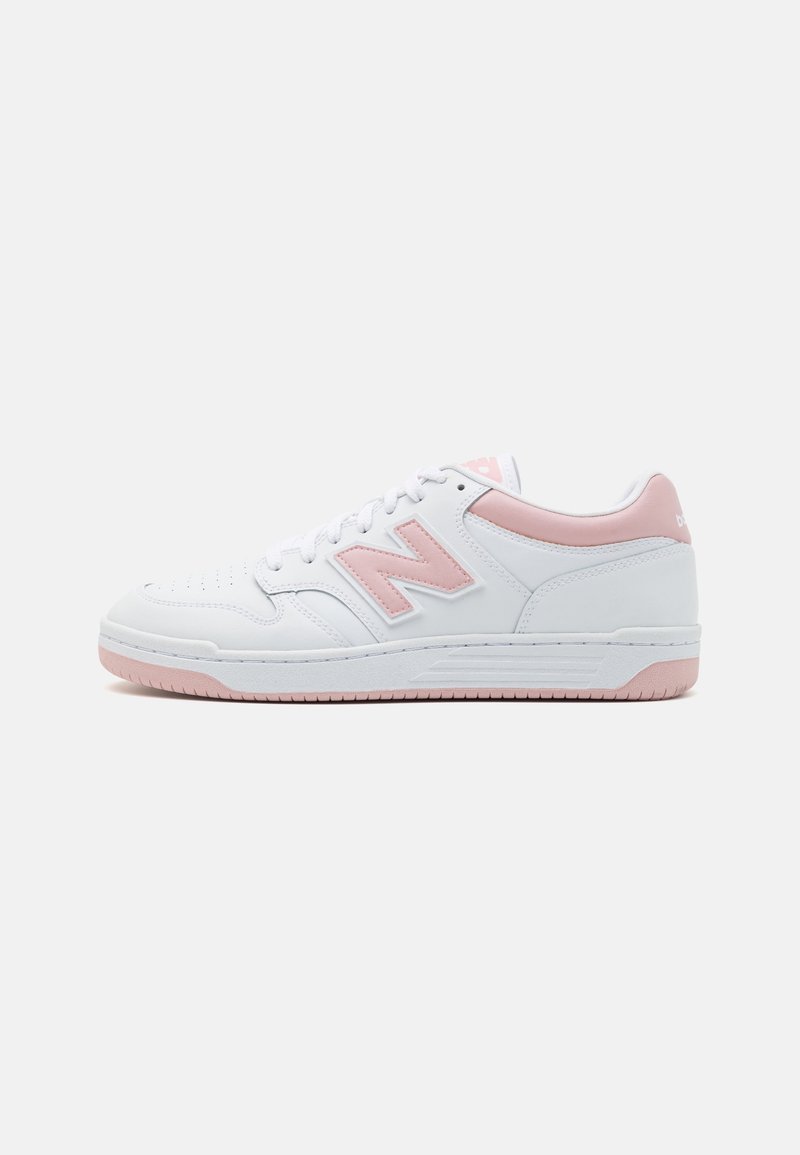 Baskets basses blanches avec des accents rose clair sur le logo, le talon, la semelle et la languette, design minimaliste, vue latérale sur fond blanc.