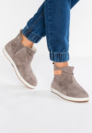 Grey suede ankle boots with a rounded toe, elastic side panels, and a white rubber sole. Features a brown label with the brand "HUB."