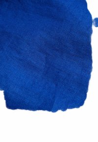 Blauer Stoff mit strukturierter Webart, der eine einheitliche Farbe zeigt, leicht ausgefranste Kanten hat und verschiedene Blautöne aufweist.