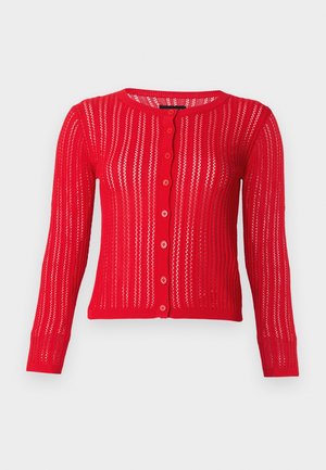 Κόκκινη ζακέτα με μακριά μανίκια και κουμπιά, με κάθετες ρίγες ανοιχτού πλεκτού και ριμπ περιθώρια, απεικονισμένη σε απλό ανοιχτό γκρι φόντο.