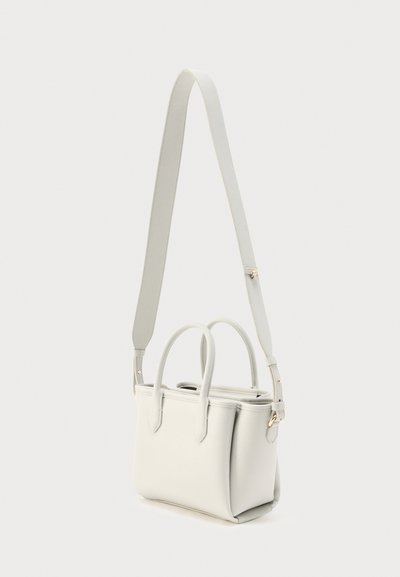 Μικρή λευκή τσάντα χειρός από δέρμα με δύο επάνω λαβές και ένα ρυθμιζόμενο λουρί ώμου σε απλό φόντο.