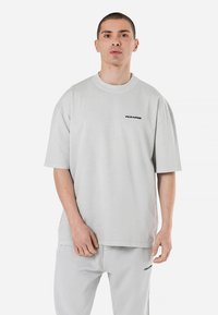 Hellgraues, oversized T-Shirt aus Baumwollmischung. Mit Rundhalsausschnitt und kurzen Ärmeln. "PEGADOR"-Logo in Schwarz auf der linken Brust.