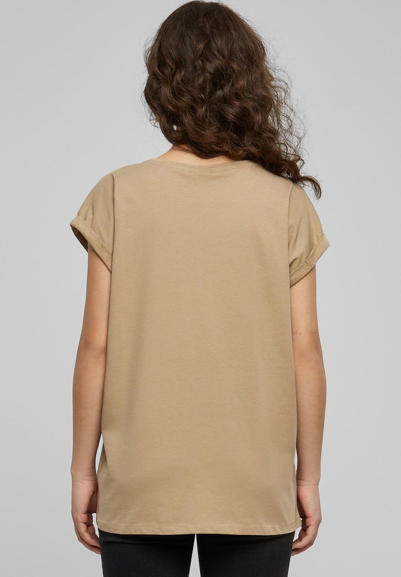Beige t-shirt i bomull med uppvikta korta ärmar, rund halsringning och avslappnad passform. Slät textur, medellång och med rak nederkant.