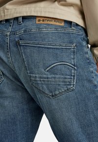 G-Star Raw denimjeans i en blekt blå tvätt. Har en bakficka med sömnadsdetaljer och en läderlogotyp på midjebandet.