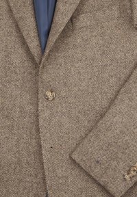 Bruine blazer in visgraatpatroon met een geknipt kraag, twee knopen en een borstzak. De stof heeft een gestructureerde afwerking.