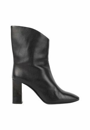 Bota de mujer de cuero negro hasta media pantorrilla con puntera puntiaguda y tacón alto grueso, vista de lado sobre fondo blanco.