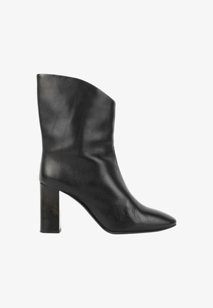 Bota de mujer de cuero negro hasta media pantorrilla con puntera puntiaguda y tacón alto grueso, vista de lado sobre fondo blanco.