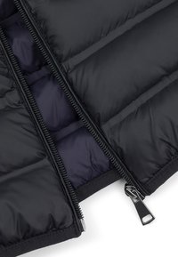 Czarna kurtka puchowa z dwukierunkowym zamkiem. Zewnętrzny materiał jest gładki, podczas gdy wewnętrzna podszewka ma kontrastujący ciemnoniebieski kolor.