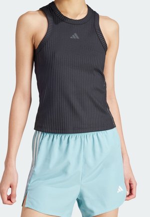 Haut de sport sans manches noir côtelé associé à un short de sport bleu clair avec des rayures blanches et des logos.