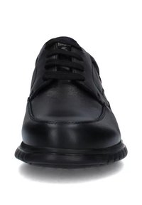 Scarpe in pelle nera con lacci, dalla finitura liscia, punta tondeggiante e cuciture a contrasto lungo i bordi. La suola in gomma è leggermente rialzata.