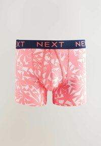 Boxer-briefs roses avec un motif de feuilles tropicales blanches, dotés d'une taille navy avec "NEXT" en lettres roses. Tissu doux et extensible.