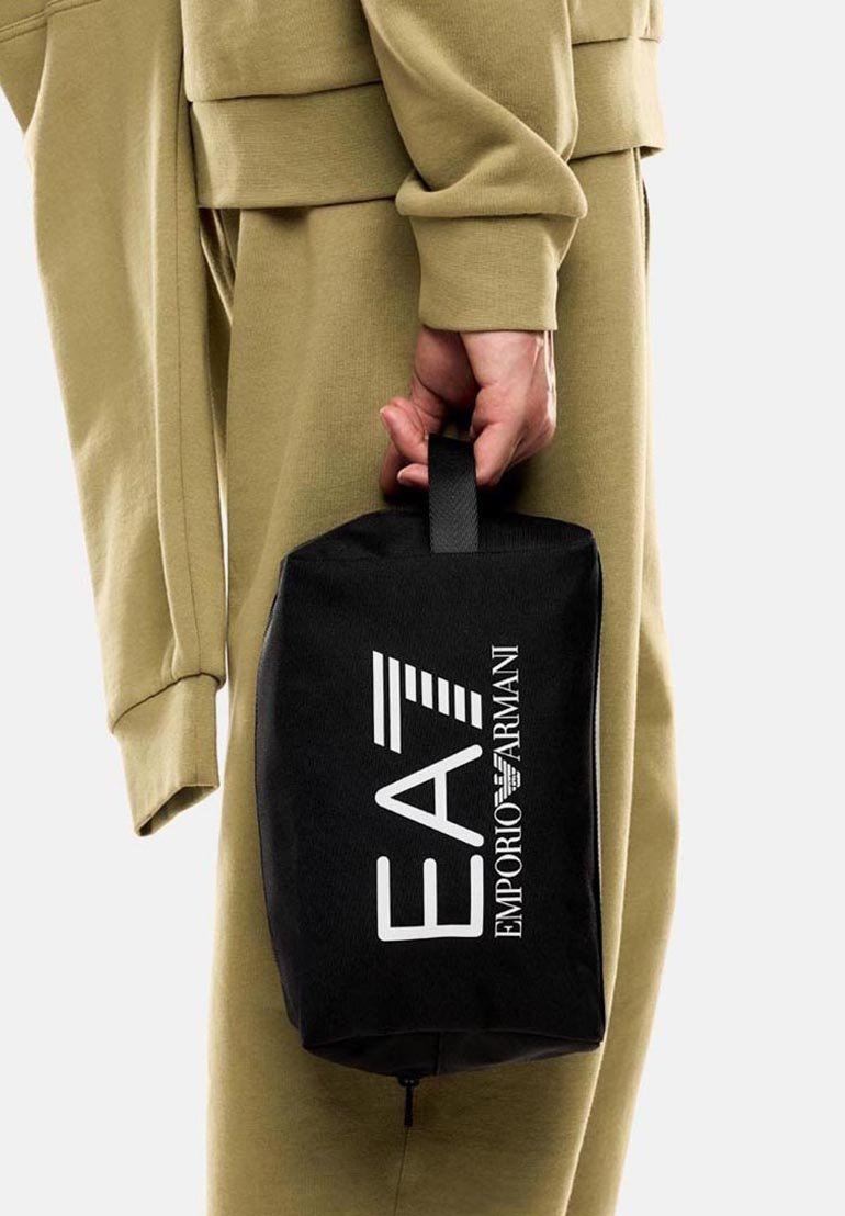 Neceser de marca negro con asa en la parte superior, que presenta el logo "EA7 EMPORIO ARMANI" en blanco, hecho de tela resistente, de forma rectangular.