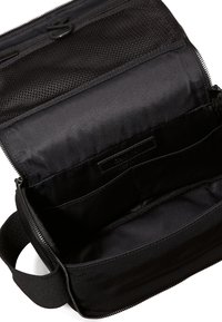 Borsa da viaggio in tessuto nero con chiusura con zip, tasca interna in rete e scomparti multipli per l'organizzazione. Texture liscia.